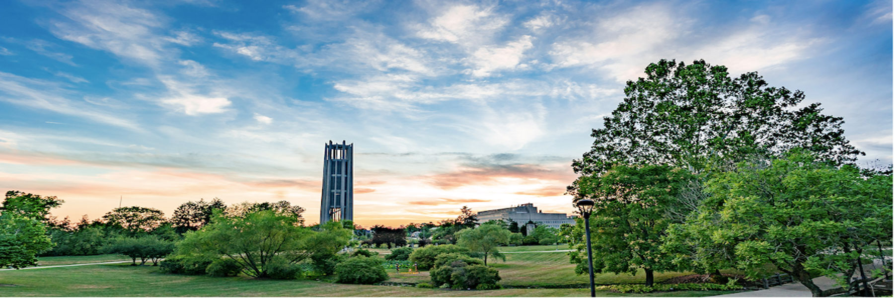 Clock tower in middle of IU Bloomington campus with sunset.